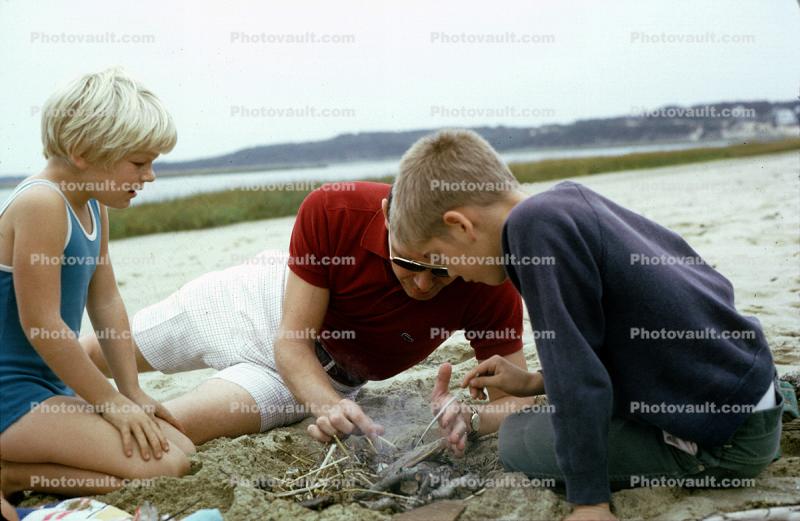 Dad with Daughter and Son, beach, sand, starting a fire, 1960s