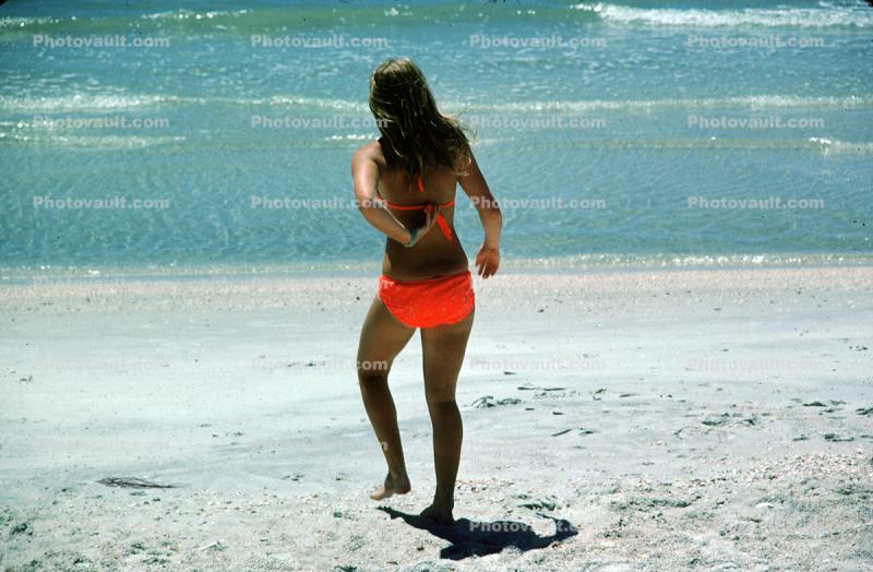 Woman walks into the water, beach, tanning, sun worshipper, bikini