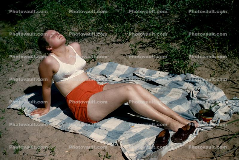 Woman in a bra sunning herself, 1950s