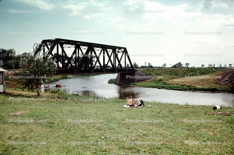 Couple Picnic, Truss Bridge, River, Grass Field