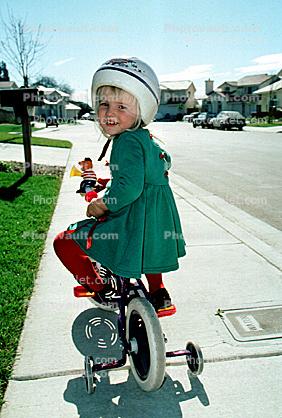 Girl learning to ride a bike, training wheels, helmet, headgear