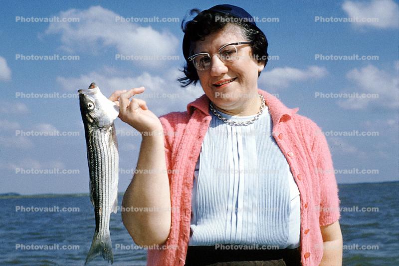 Gwen wearing a sweater, fisherwomen, woman, fish catch, glasses, necklace, arm, Outer Banks, North Carolina, 1960s