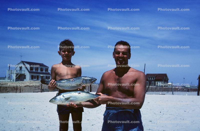 Boy and Father showing off fish catch, Cape Cod, 1950s