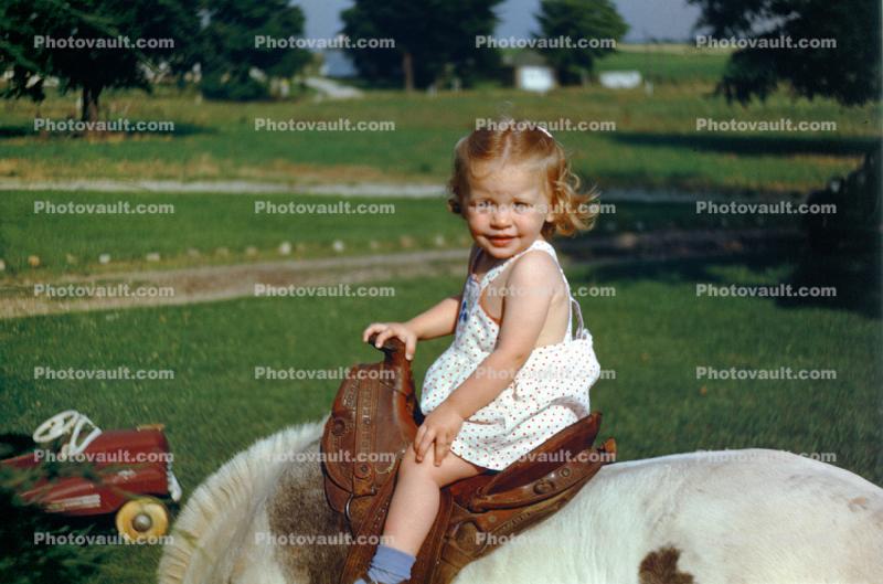 Funny Little Girl in a Pony Saddle, cute, 1950s
