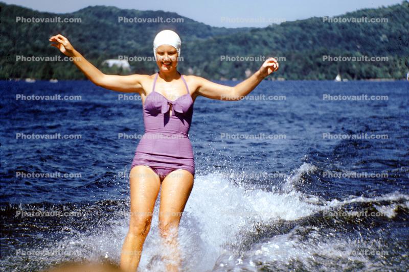 Woman in a purple all in one, aio, swimsuit, one piece, bathing cap, water, 1950s
