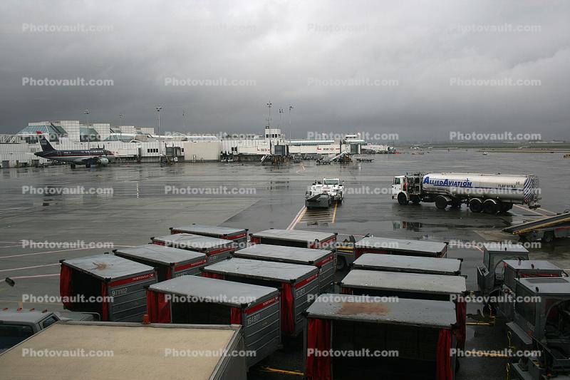 LaGuardia Airport (LGA), cart, jetway, refueling, fuel truck, Aircraft Tow Tractor, Towtruck, terminal, rain, rainy, inclement weather, precipitation, Airbridge, pushback tug