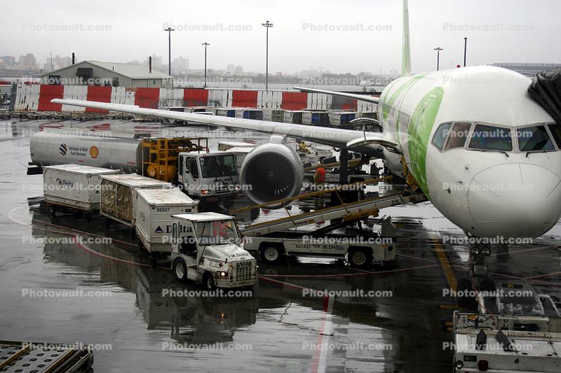 LaGuardia Airport (LGA), Boeing 757, Shell refueling truck, carts, belt loader, Baggage Tractors, Song Airline DAL, rain, rainy, inclement weather, precipitation