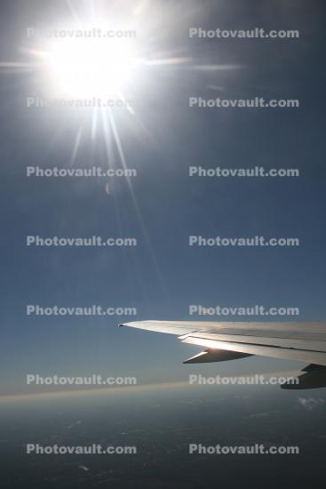 Sun and a lone Wing in Flight