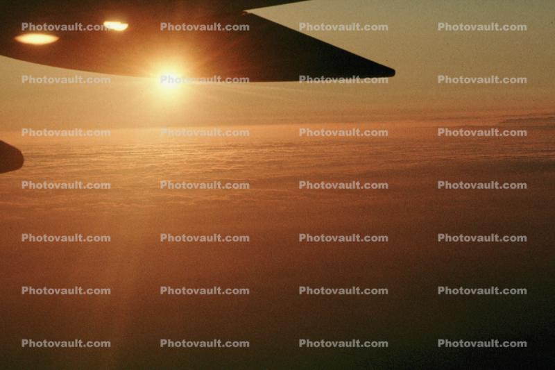 wing in flight, sunset, clouds