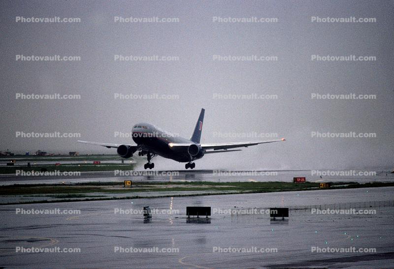 United Airlines UAL, Boeing 777, San Francisco International Airport (SFO), rain, inclement weather, wet