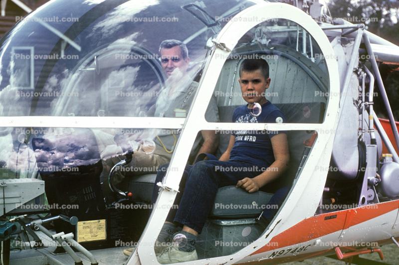 Father and Son sitting in a  Hiller UH-12E Helicopter, N9748C
