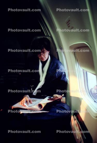 Woman sitting, reading a magazine, window, seat