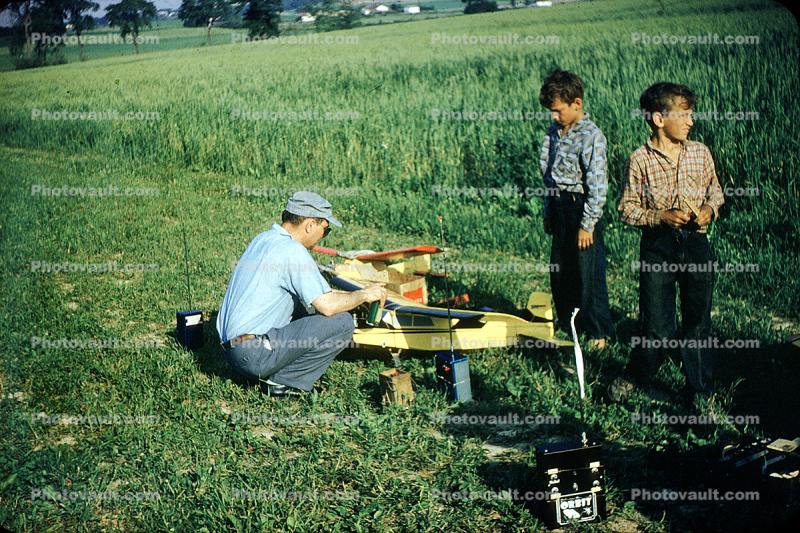 Boys watching father prepare airplane for flight, Man, Boys, guy, January 1959, 1950s