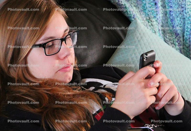 Teen Girl playing with her hand held device, I phone, Iphone, I-phone, cell phone, hand held device, hand, fingers, monitor, cloud computing, Iphone-4s