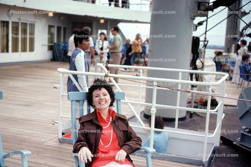 Woman lounging on ship deck, Passengers, July 1973, 1970s