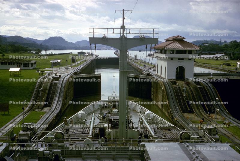 a ship about to go through a partially open lock in the Panama Canal, Mules, Cog Railway, Rail, Gatun Locks, 1966, 1960s