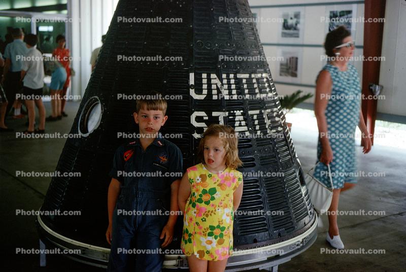 Boy and Girl stand in front of the Mercury Space Capsule, 1960s