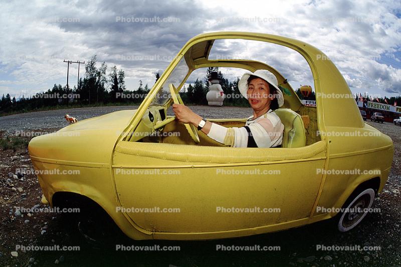 Japanese lady driving a funny car, hat, smiles, automobile