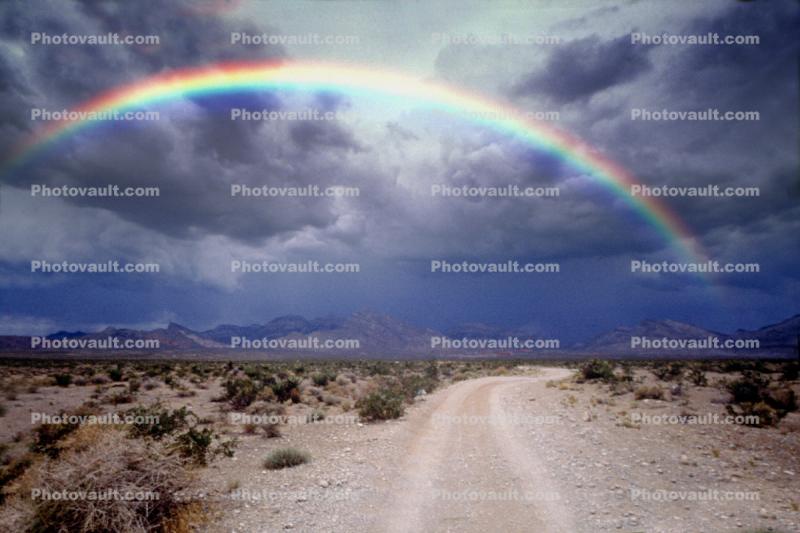 Rainbow over a dirt road, unpaved