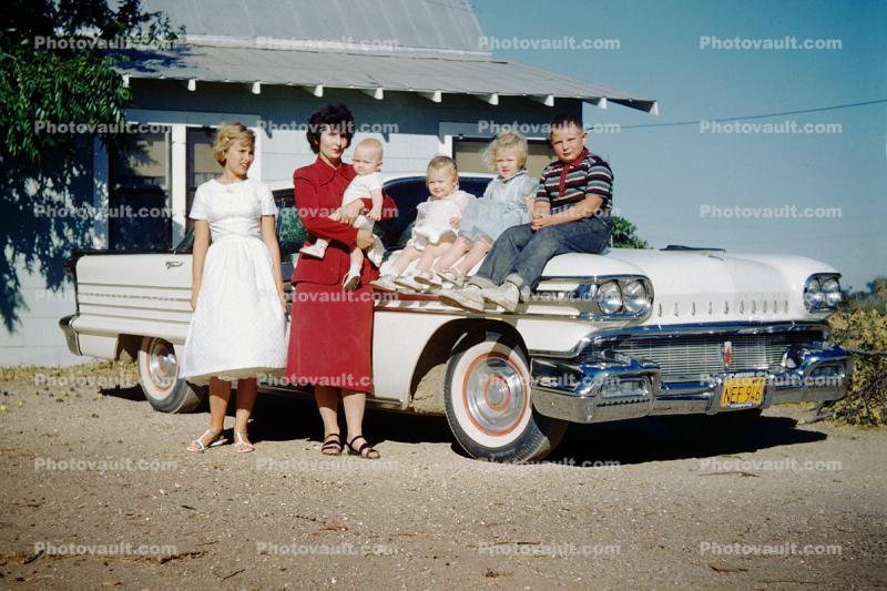 Family Sits on an Oldsmobile car, 1950s