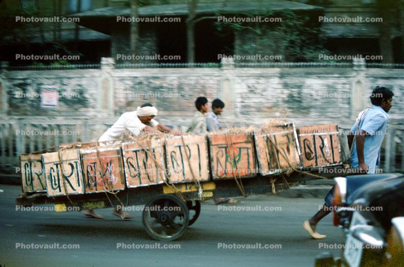 Men pushing and pulling on a cart with bricks, on the Streets of Mumbai