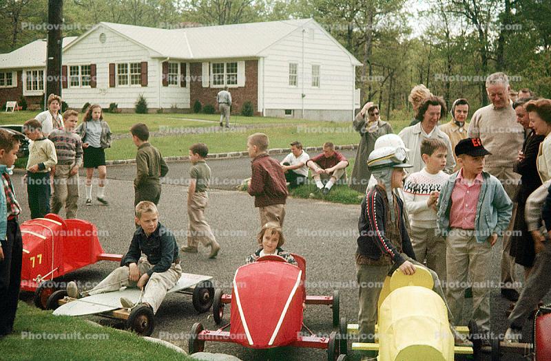 Smiling Girl in her Downhill Racer, Soap Box Derby, suburbia, home, house, street, 1950s