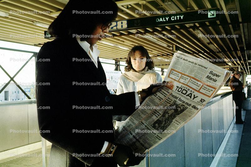 reading a newspaper, Daly City Station, Bay Area Rapid Transit, BART, Oakland Tribune, commuters, 1980s