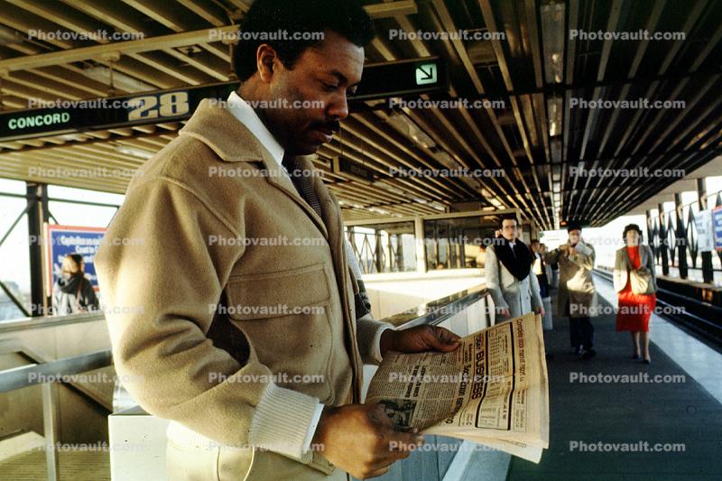 Man reading a newspaper, Daly City Station, Bay Area Rapid Transit, BART, commuters, 1980s