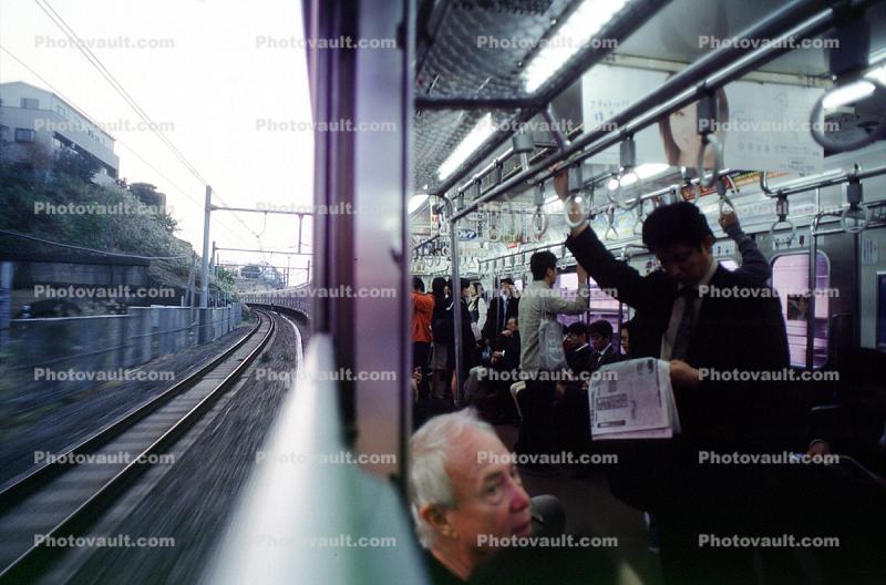 Inside outside, railcar, commuters, reading newspaper, interior, exterior