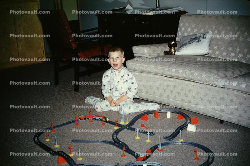 Boy and his toy railroad set, tracks, Pajamas, sofa, 1960s