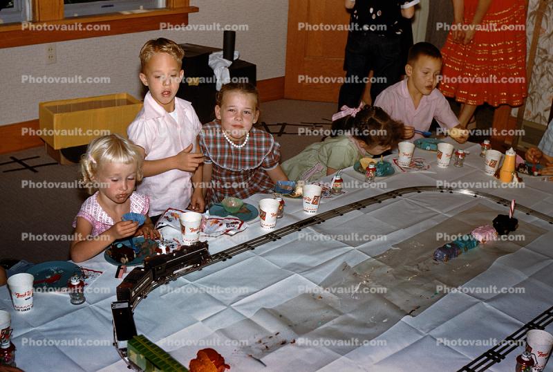 Girls and Boys Celebrating a Birthday around a Toy Train Set, 1950s