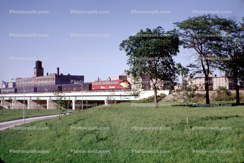 Rock Island freight train, bridge, lawn, trees, skyline, buildings