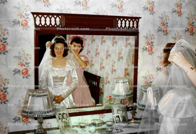 Woman prepares for her wedding, mirror, satin dress, 1940s