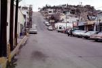 street scene, cars, buildings, hill, automobile, vehicles, Nogales, 1960s