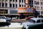 Cinerama Holiday, Motherhood Maternity Shops, marquee, J.D. Creger & Co. Stocks and Bonds, cars, street, Ford, 1955, 1950s