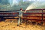 Man spraying water, grass fire, wildfire, Wild land Fire
