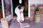 Woman picks up the morning paper, ENCV01P03_11