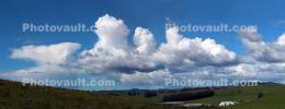 Cumulus Clouds over the green hills panorama
