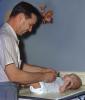 Father Changes Babies Cloth Diaper, Table, Cute, Smiles, 1950s