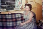 Woman sitting on a Sofa, inside a trailer, windows, 1940s