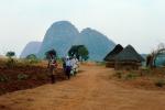 Women Walking with Balanced Bag on her head, Dirt Road, unpaved, round homes, huts, Village, Dzimwe