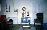 Television Screen, fireplace, curtains, chairs, scale, clock