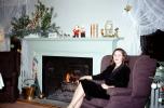Smiling Lady Sitting, mantle, fireplace, curtains, Christmas decorations, 1950s, PDFV02P13_08
