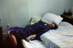 Woman Laying on a bed, pillows, quilt