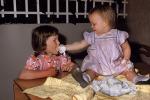 Toddler feeds her sister, Girl, Cake, Pink Dress, 1950s