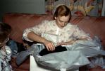 Pretty Lady opens a present, gift, sofa, unwrapping presents, 1950s