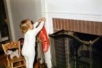 Girl hangs her Christmas Stocking, fireplace, 1950s, PHCV04P10_04