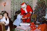 Santa Claus handing a present to a Girl, Boys, 1950s