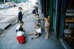 Playing Marbles, boys, girls, sidewalk, Bangkok Thailand, October 1962, 1960s, PLGV03P09_14