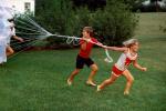 Playing with a Parachute, girl, boy, running, barefoot, lawn, 1960s